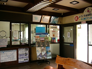 窓口の横にはサッシの引き戸。片方の扉の前にはパンフレットを建てて並べるラックが置いてある。