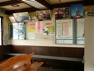 壁に設置された焦げ茶の長椅子。天井付近にはパネル多数。