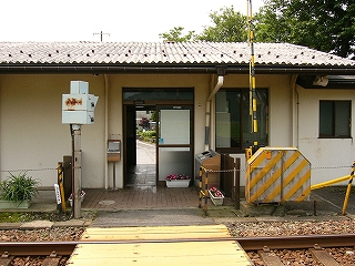 クリーム色の壁の面屋の易者のサッシの間口に向かう踏み切り。