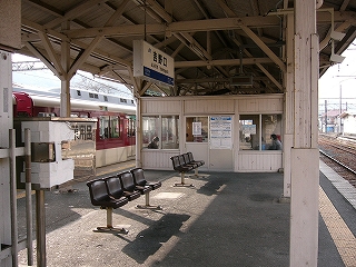 待合室への出入り口前。吊り下げられた電照式駅名標の下には一人掛けの椅子が何客か設置されている。