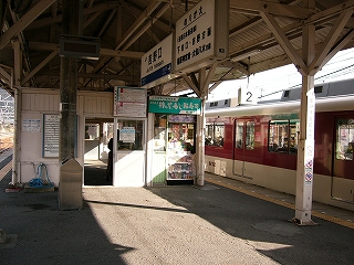待合室前と上屋下から吊られた電照式駅名標。