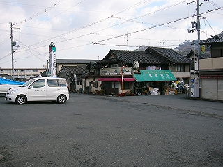 広いアスファルトの敷地の向こうに古い商店が一件。