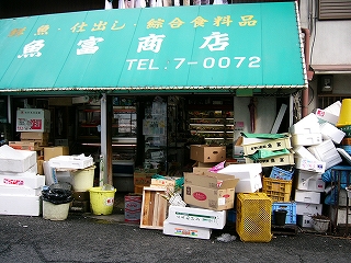 発泡スチロールやプラスチックの業務用ケースの積まれた店の前。