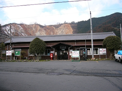 瓦葺、焦げ茶の壁の横長の駅舎。